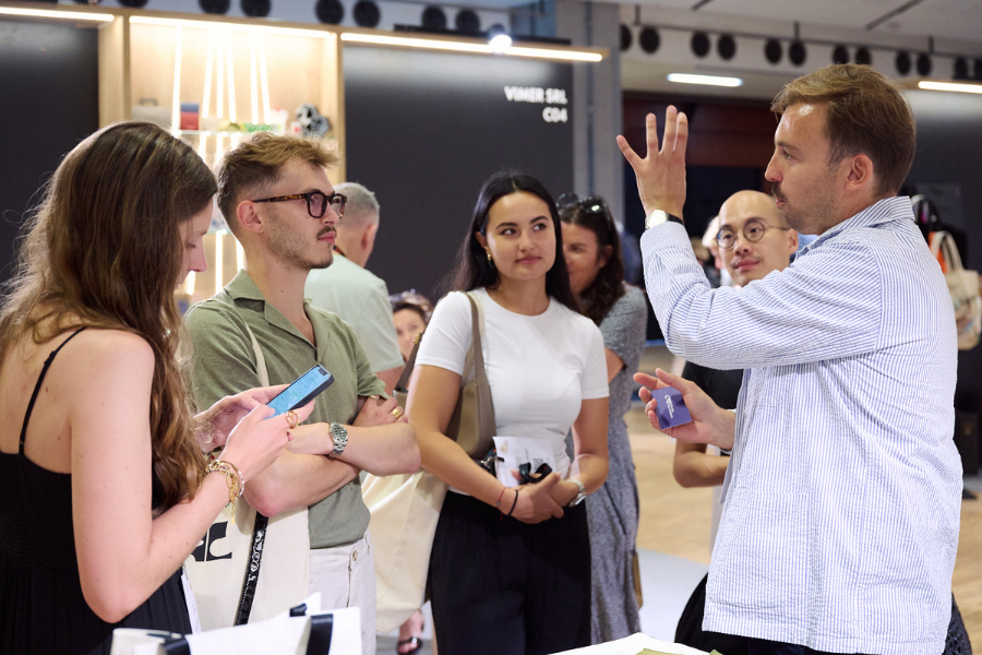 des visiteurs qui découvrent les matières d'un produit exposant écoresponsable