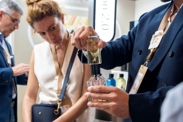 Des visiteurs et des exposants qui échangent sur un stand autour d'un produit packaging