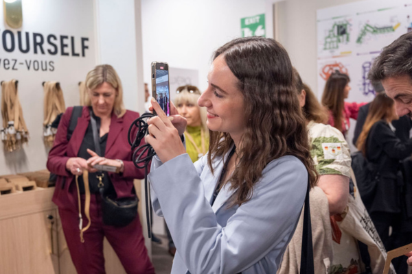 Des visiteurs et des exposants qui échangent sur un stand autour d'un produit packaging