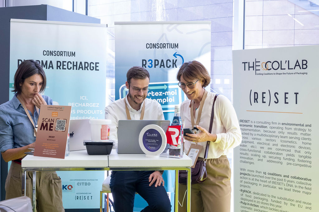 deux personnes qui sourient devant un ordinateur et qui discutent