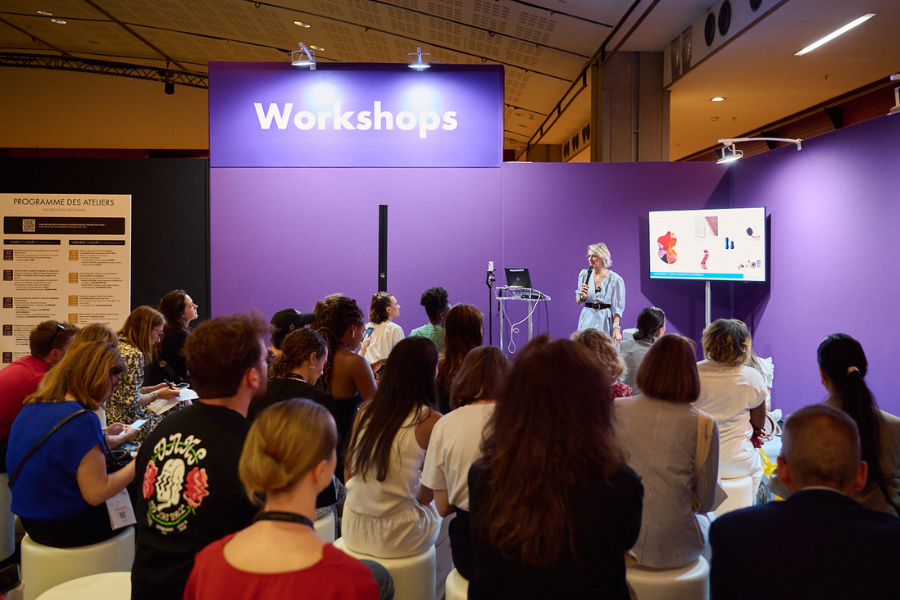 des personnes qui participent à un atelier workshop animé par un intervenant qui parle au micro