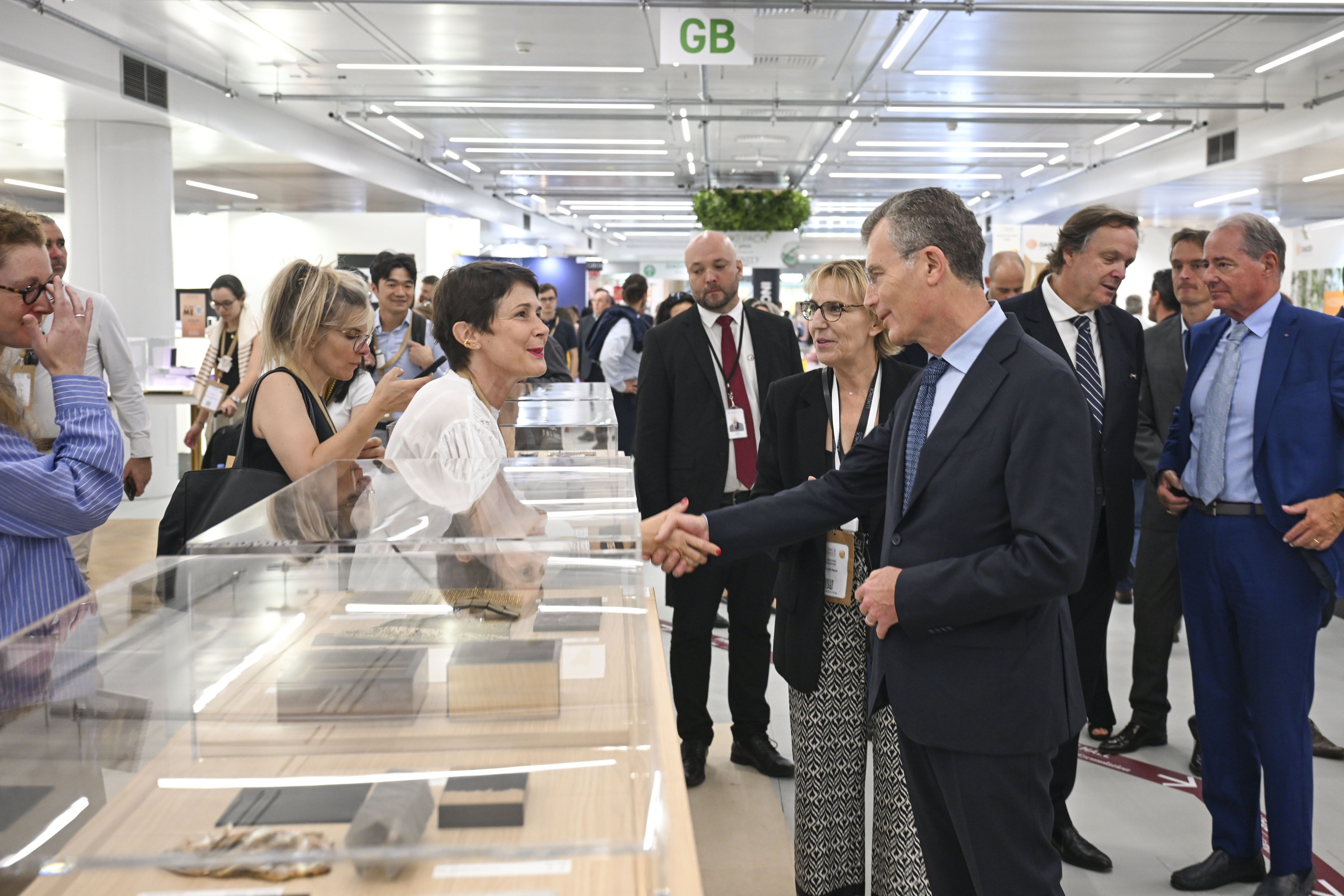 une visite de ministre avec des délégations et des personnes qui se serrent les mains dans un salon